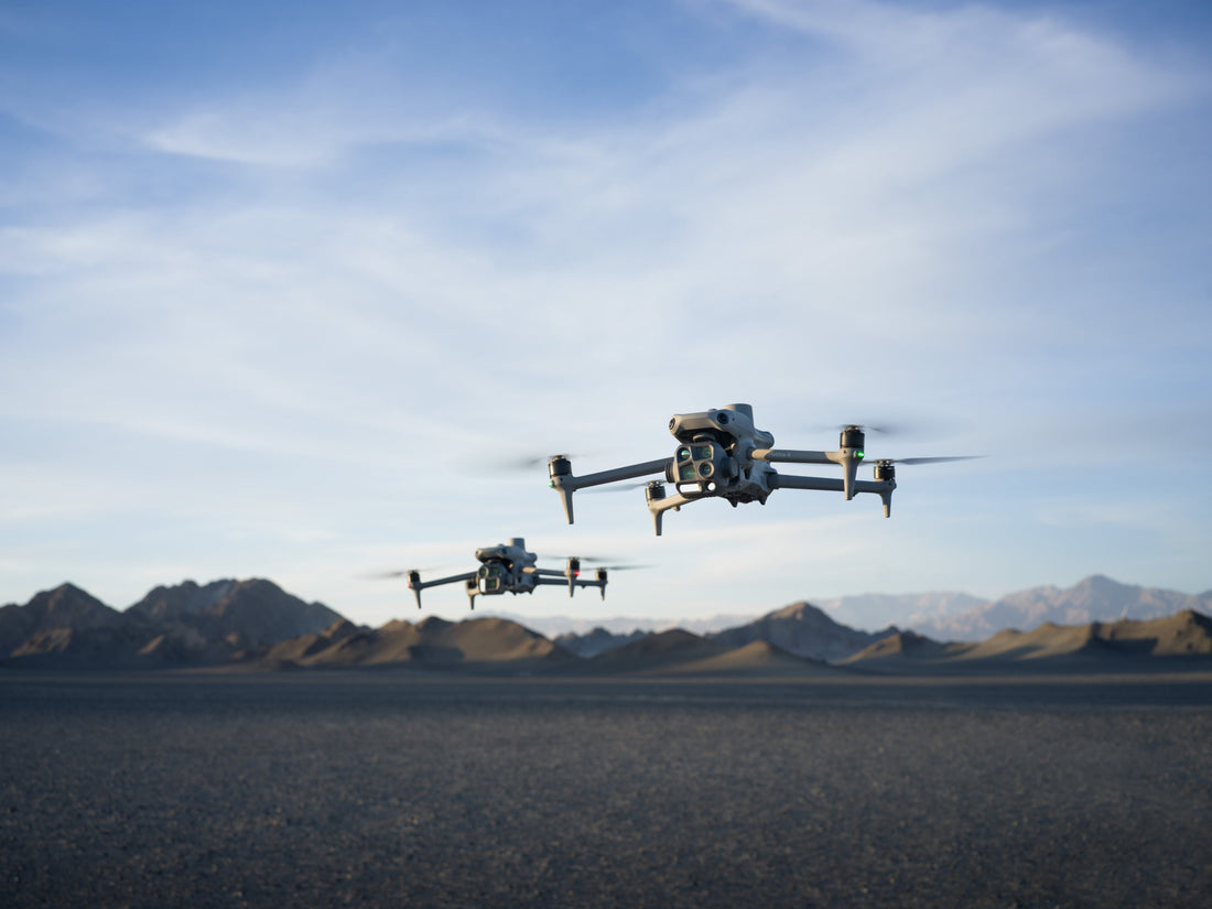 Two DJI Matrice 4 drones flying over a rugged desert landscape, demonstrating advanced aerial capabilities for enterprise and industrial applications.